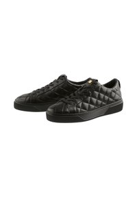 Black quilted leather sneakers with flat laces, rounded toe, and rubber sole featuring textured ridges for grip and style.