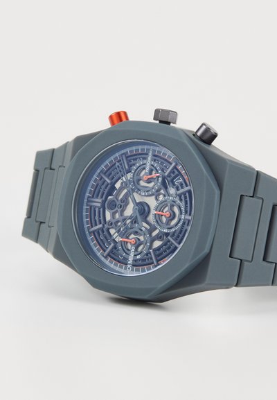 Gray silicone watch with an octagonal case, clear dial showcasing intricate mechanisms, red and black accents, and three sub-dials.