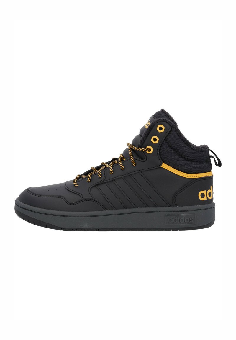 Zapatillas deportivas negras de corte alto hechas de cuero sintético con detalles en amarillo. Cuentan con cuello acolchado, detalles de cordones y suela de goma texturizada.