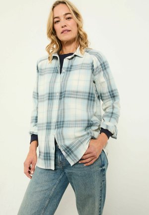 Button-up plaid shirt in light blue and white, made of soft fabric. Features a relaxed fit, chest pocket, and rolled-up sleeves.