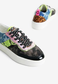 Baskets multicolores avec des textures en denim, daim et imprimé serpent, dotées de lacets noirs, d'une pointe brillante et d'accents imprimé animal sur le talon.