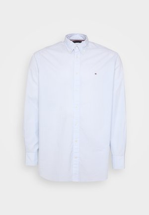 Cămașă button-up de culoare albastră deschisă cu mâneci lungi, fabricată din bumbac cu un model texturat, având un mic logo pe piept și un guler.