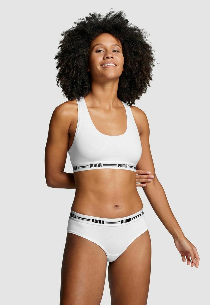 Weißer Sport-BH und Unterhose mit einem schwarzen Logo-Band. Die Artikel sind mit einer glatten Textur und einer einfachen Form ausgestattet, die für Komfort und Unterstützung sorgt.