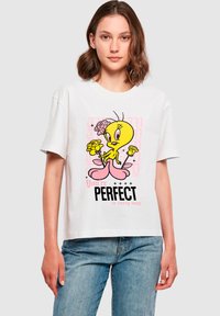 Valge puuvillane T-särk lühikeste varrukatega, millel on värvikas Tweety Bird graafika ja tekst "Sa oled IGAS MÕTTES Täiuslik" all.