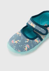 Sapato Mary Jane de tecido azul com padrão de unicórnio, tira ajustável com velcro e sola de borracha verde menta.