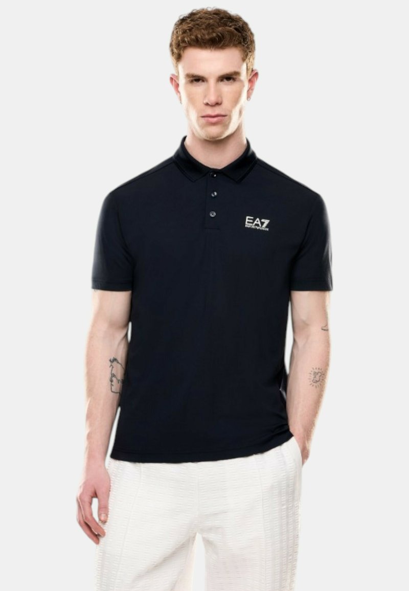 Camiseta polo de color navy con mangas cortas, tres botones y logo de EA7 en el lado izquierdo del pecho. Hecha de una tela suave y ligera.