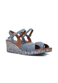 Denim wedge sandals feature cross-strap design, open toe, and a woven jute-like heel with beige, blue, and gray color accents. Adjustable buckle closure.
