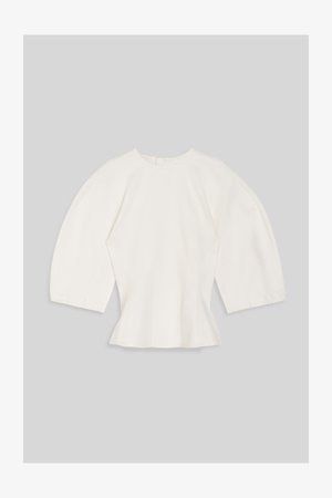Hvid tætsiddende bluse med brede trekvartærmer og rund halsudskæring på grå baggrund.