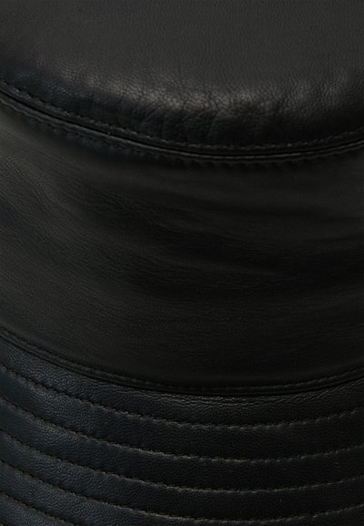 Puf din piele neagră cu vârf rotunjit și textură ribbed pe laterale. Prezintă cusături vizibile și o finisare netedă.