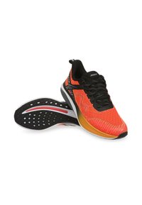 Scarpe da corsa rosse e arancioni con una parte superiore texturizzata, lacci neri e una suola nera a contrasto con un design del battistrada a motivi.