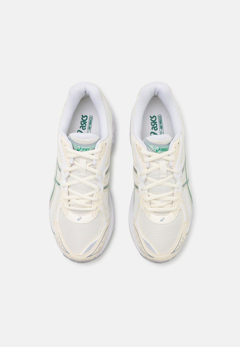 Weiße Netz-Sportschuhe mit grünen Akzenten, die ein Schnürdesign, einen gepolsterten Schaft und eine strukturierte Gummisohle für besseren Halt bieten.