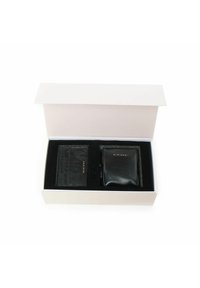Set di portafoglio in pelle nera e portacarte in una scatola bianca con interno nero. Presenta un logo impresso su entrambi gli articoli, superfici lisce e testurizzate.