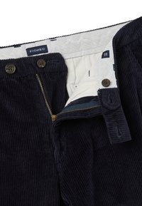 Marineblauwe corduroy broek met een rits- en knoopsluiting. Heeft een voering van lichte stof en een intern merklabel.