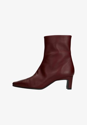 Bordeaux leren enkelboots met een spitse neus, een gladde textuur en een bescheiden blokhak. Slank, passend ontwerp met minimale stiksels.