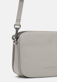 Hellgraue Leder-Crossbody-Tasche mit glatter Textur, abgerundeten Ecken und silbernen Beschlägen. Verfügt über einen Reißverschluss und ein Logo-Detail.