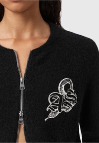 Cardigan zip-up in lana nera con scollo rotondo, caratterizzato da una superficie testurizzata e un design con serpente ricamato in bianco e lettere sul petto.