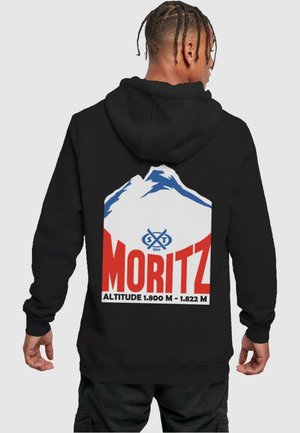 Schwarze Kapuzenjacke mit einem großen Grafikdesign auf der Rückseite, das blaue und weiße Berge zeigt, sowie fettem roten Text mit der Aufschrift "MORITZ" und Höhenangaben.