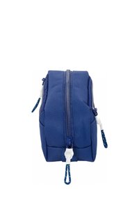 Granatowa torebka typu soft-shell o teksturowanej powierzchni, z podwójnym zamknięciem na zamek oraz dekoracyjnymi uchwytami do zamków z zielonymi kropkami.