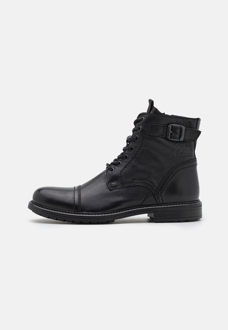Bottine noire en cuir à lacets avec bout renforcé, bride latérale à boucle et talon bas, vue de côté extérieur sur fond uni.