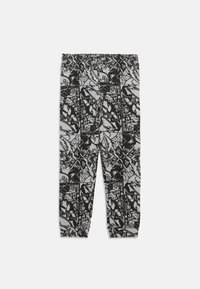 Schwarz-weiß gemusterte Hosen mit lockerer Passform, die mit grafischen Illustrationen und einem gerafften Bund für zusätzlichen Komfort versehen sind.