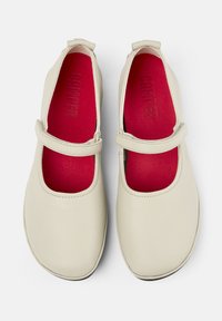 Scarpe in pelle color crema chiaro con forma arrotondata, dotate di una soletta rossa in contrasto e di una fascia sul piede per una calzata sicura.