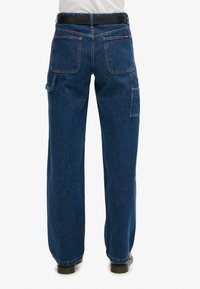 Pantalones cargo de mezclilla en azul oscuro, con un corte holgado, múltiples bolsillos y costuras en contraste. Incluye presillas para el cinturón.