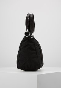 Borsa in tessuto nero con fondo arrotondato, doppi manici in tela e un anello metallico decorativo nella parte superiore. Design semplice e senza fronzoli.