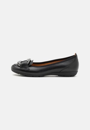 Black leather ballet flat with a rounded toe, featuring a decorative bow and silver hardware accent. The sole is flexible with a slight heel.