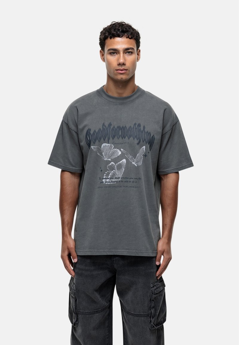 Losse grijze katoenen t-shirt met korte mouwen, voorzien van vlinderafdrukken en gestileerde tekst. Crew neck ontwerp met een licht verweerd uiterlijk.