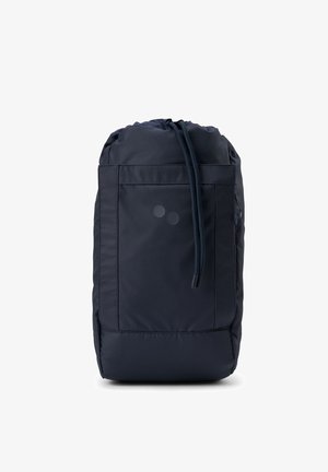 Navy drawstring backpack with two round accents, large main compartment, and exterior pocket. Made of durable fabric with a smooth texture.