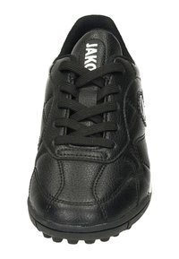 Baskets noires avec dessus en cuir texturé, semelle en caoutchouc avec des crampons, et lacets noirs. "JAKO" imprimé en blanc sur la languette.
