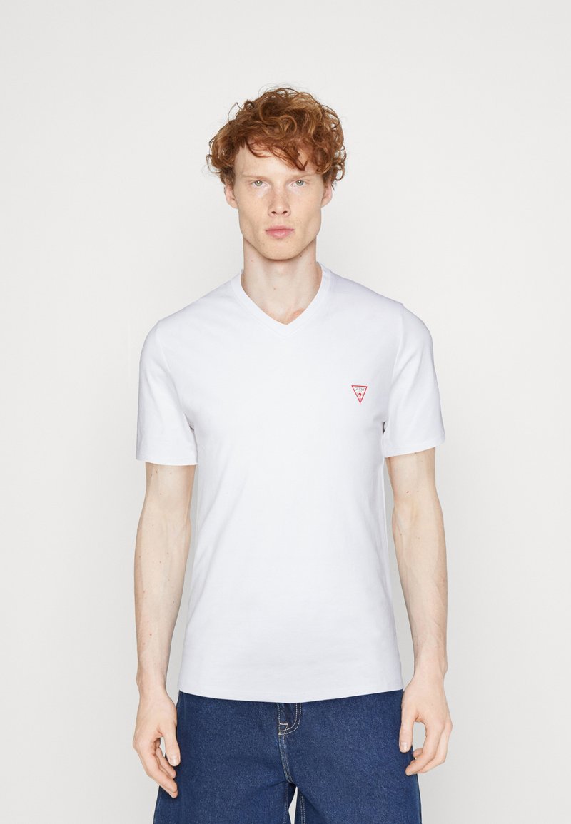 Hvid bomulds t-shirt med V-hals og korte ærmer. Har et lille rødt trekantet logo på venstre bryst. Blød tekstur, standard pasform.