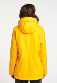 Heldere gele waterdichte jas met capuchon. Heeft een gladde, glanzende textuur en lange mouwen. De achterzijde toont een recht gesneden ontwerp.