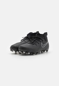 Čierne futbalové kopačky s aerodynamickým dizajnom, textúrovaným zvrškom, zakrivenou špičkou a bielym logom Nike. Obsahujú viacero vstavaných kolcov pre lepšiu trakciu.