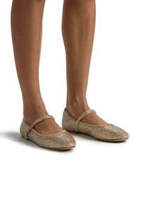 Gouden mesh ballet flats met twee verstelbare banden, een ronde neus en een platte hak, met een gestructureerd oppervlak met kleine glanzende accenten.