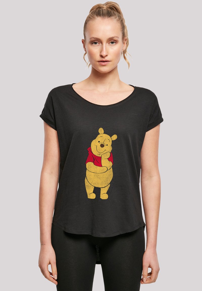 Sort T-shirt med korte ærmer, der har en gul tegneserie-bjørn iført en rød skjorte. T-shirten har en afslappet pasform og er lavet af et blødt, let materiale.