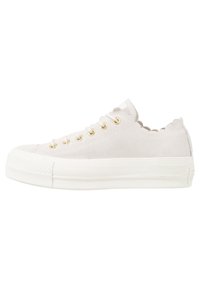 Sneaker basse in suede bianco con bordi scallop, occhielli dorati, lacci bianchi e suola in gomma bianca spessa, vista laterale su uno sfondo bianco.