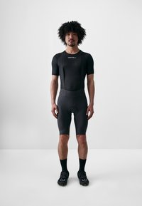 Schwarze Radsportshorts und kurzärmliges Trikot aus einem strukturierten, atmungsaktiven Material, mit einer taillierten Passform und flachen Nähten für einen hohen Komfort.