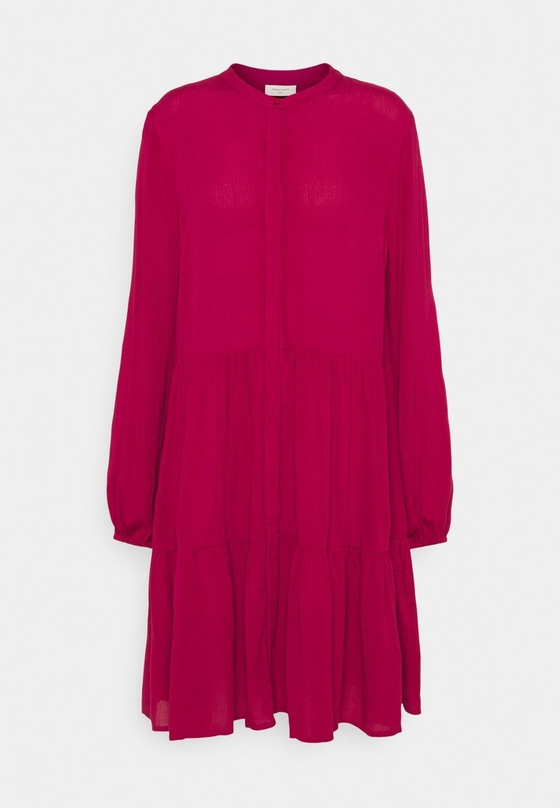 Robe rose framboise à manches longues avec un col rond et une jupe fluide à volants sur fond blanc.