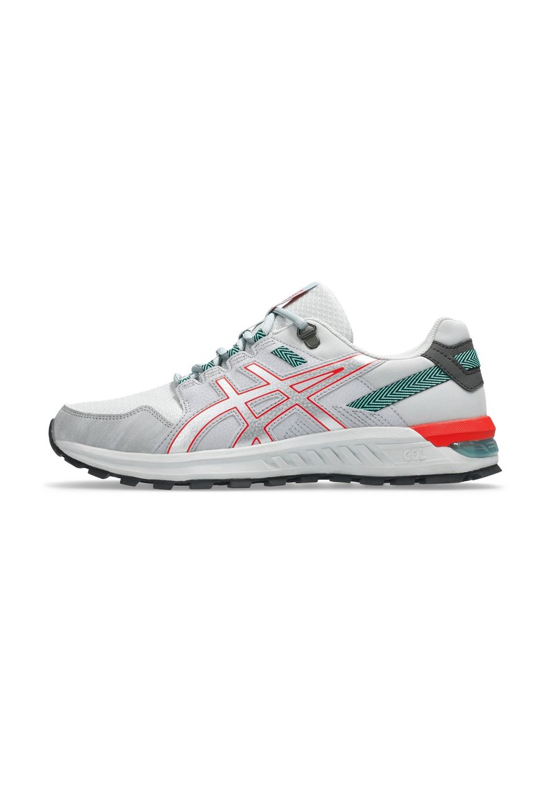 Chaussure de sport gris clair avec accents rouges et teal, tige en mesh, superpositions texturées et semelle en caoutchouc noire pour une meilleure traction.