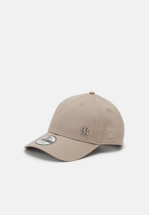 Beige baseball cap made of fabric, featuring a raised silver NY logo on front and a side logo tag. Smooth texture and curved visor.