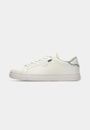 Låga vita sneakers med platt gummisula, snörning framtill, diskret logotyp på sidan och ljusgrå vadderad krage.