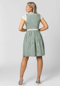 Green patterned dress with a pleated skirt, lace cap sleeves, and a waist ribbon. The back features a fitted design and soft textures.