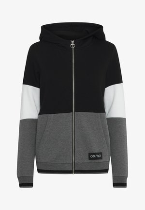 Kapitāla kapuce, izgatavota no kokvilnas maisījuma auduma, ar krāsu bloku dizainu melnā, baltā un pelēkā krāsā, priekšējiem kabatām un ribotām piedurknēm.