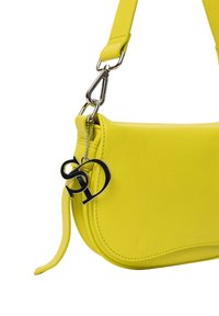 Gelbe Lederhandtasche mit geschwungener Form, ausgestattet mit einem silbernen Verschluss und einem abnehmbaren Schlüsselanhänger mit Logodetail.