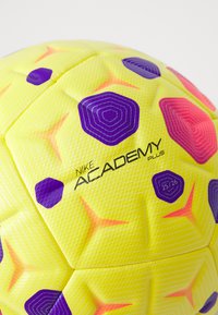 Pallone da calcio Nike Academy Plus, giallo con accenti esagonali viola e rosa, superficie testurizzata e marchio in rilievo. Design a motivo.