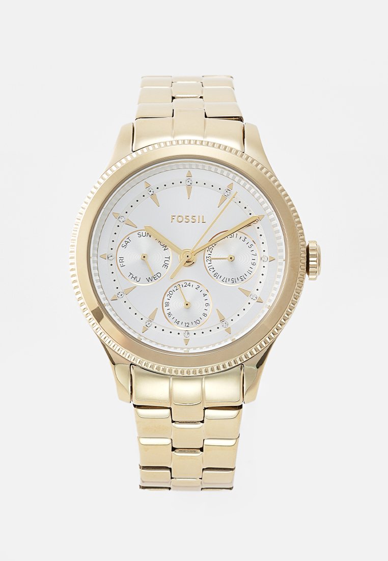 Goldfarbene Fossil-Uhr mit einem weißen Zifferblatt, strukturierten Subdials für Datum und Wochentag sowie einem metallenen Gliederarmband. Verfügt über eine strukturierte Lünette und Stundenmarkierungen.