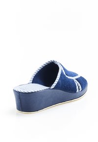 Zapatilla de plataforma azul con parte superior de toalla, forro de tela a rayas y puntera redondeada. Cuenta con una suela texturizada y detalles de ribete en blanco.
