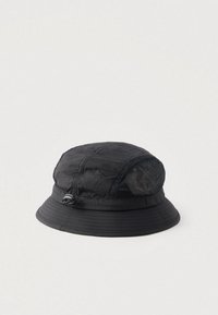 Chapeau seau noir en tissu texturé, avec un panneau latéral en mesh et un cordon de serrage ajustable pour un ajustement personnalisé.