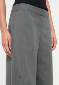 Γκρι ραμμένο παντελόνι από υφασμάτινη υφή, με ευρύ ζωνάκι μέσης και πλαϊνές τσέπες, σε ίσια γραμμή ποδιού.